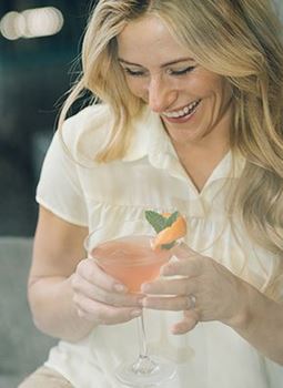 Woman with cocktail smiling