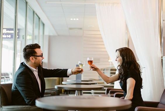 Woman and man toasting with drinks in lounge