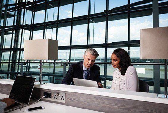 Woman talking with man in front of laptop