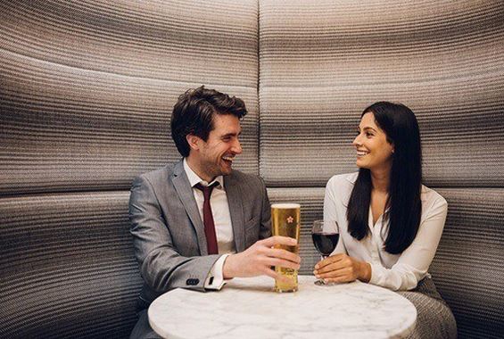 Woman drinking with man in lounge booth