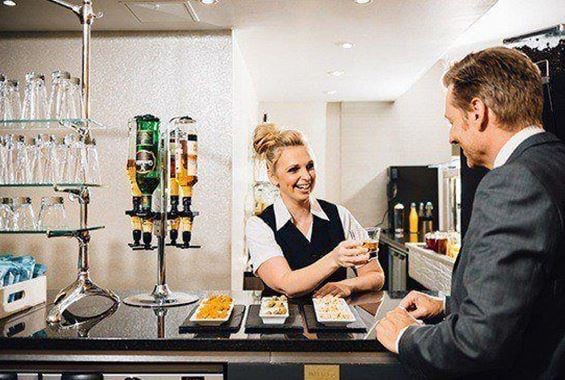 Bar staff serving customer