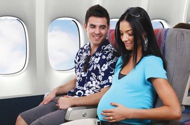 Pregnant woman on flight holding man's hand