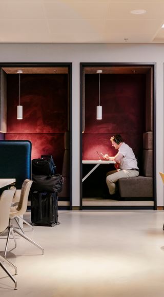 A Man Using The Work Stations At The Aspire Lounge 26 At Schiphol Airport