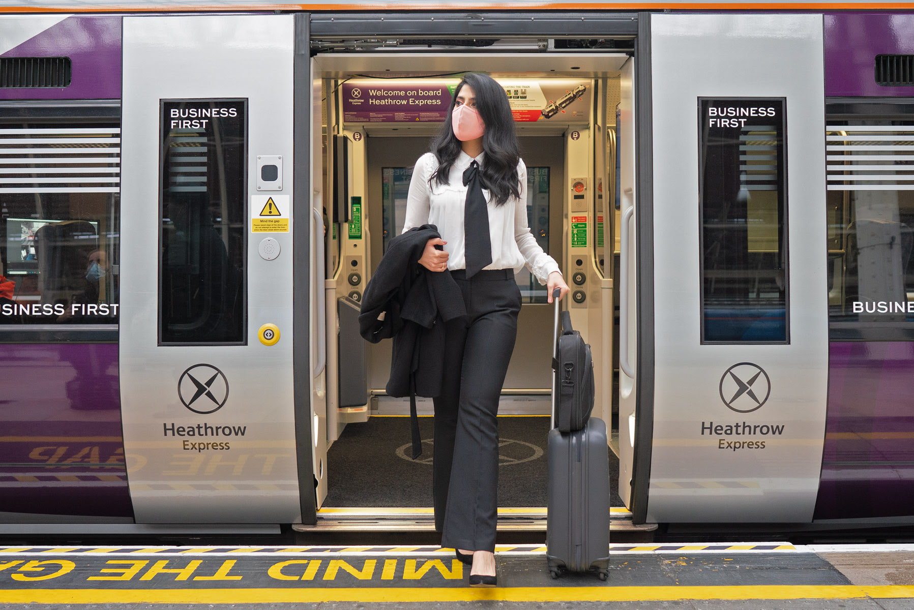 A woman stepping off the Heathrow Airport train 