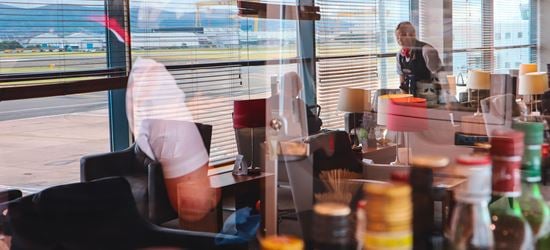 Image of staff in Aspire Lounge at Belfast City Airport with reflection of Samson and Goliath cranes