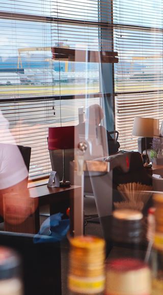 Image of staff in Aspire Lounge at Belfast City Airport with reflection of Samson and Goliath cranes